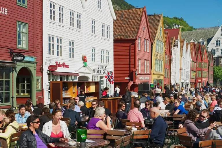 אנשים אוכלים ארוחת צהריים במסעדות רחוב בברוגן בברגן, נורבגיה. ברוגן הוא אתר מורשת עולמית של אונסק"ו.